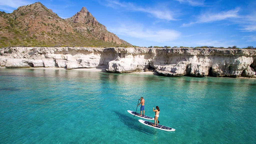 Un hombre y una mujer practicando paddle surf en una isla de Loreto,Baja California Sur