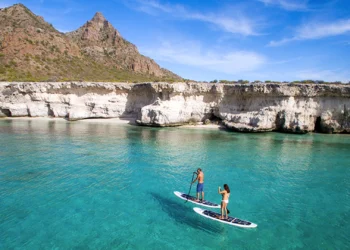 Un hombre y una mujer practicando paddle surf en una isla de Loreto,Baja California Sur