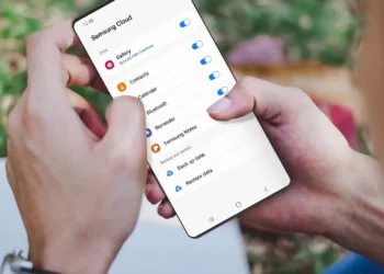 Una mujer sosteniendo un teléfono celular samsung galaxy, abriéndo la configuración de Samsung Cloud